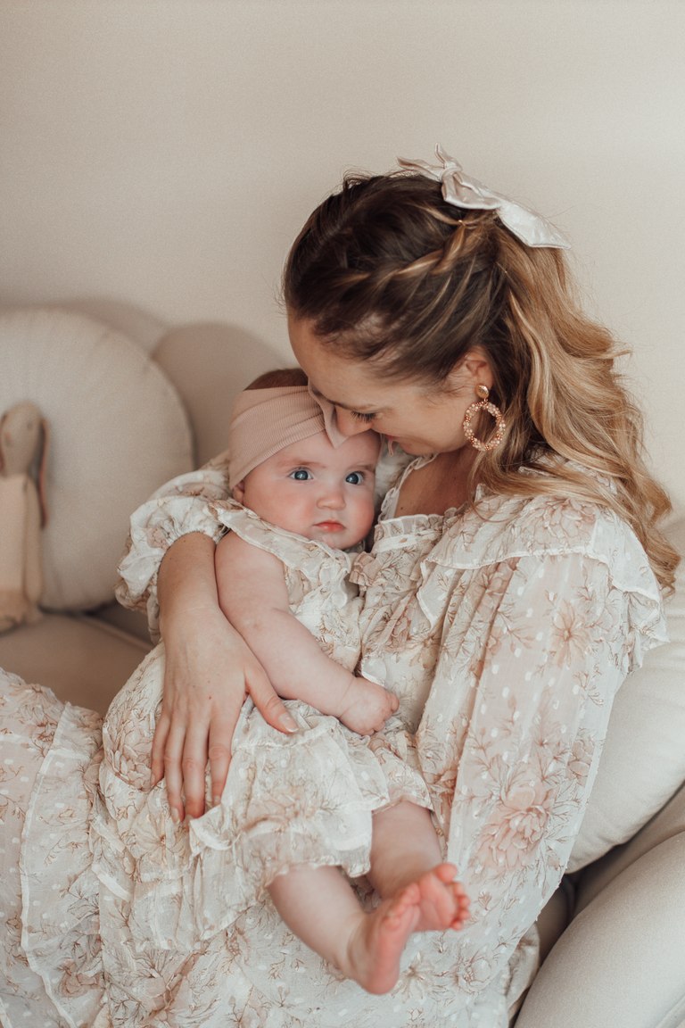 Mutter küsst ihr Baby auf den Kopf