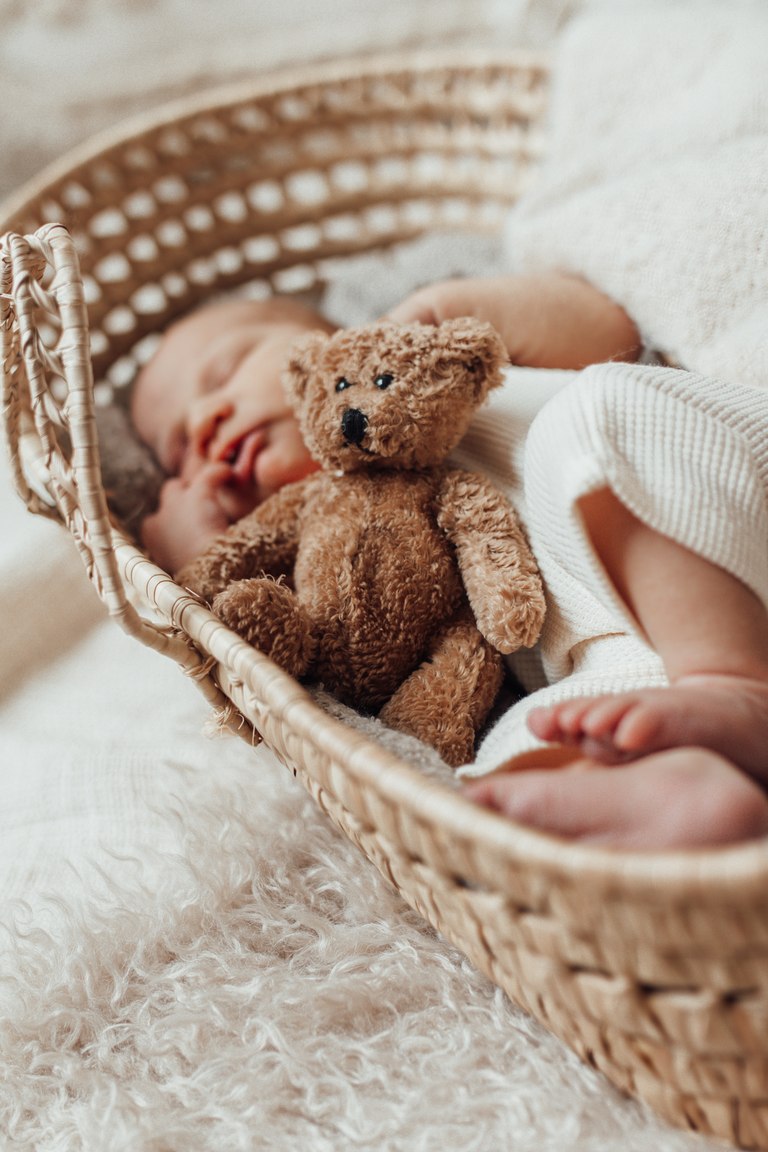 Schlafendes Baby neben einem kleinen Teddybären