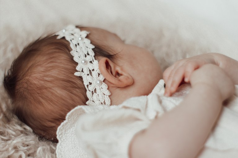 Schlafendes Baby mit einem zarten Blumenband