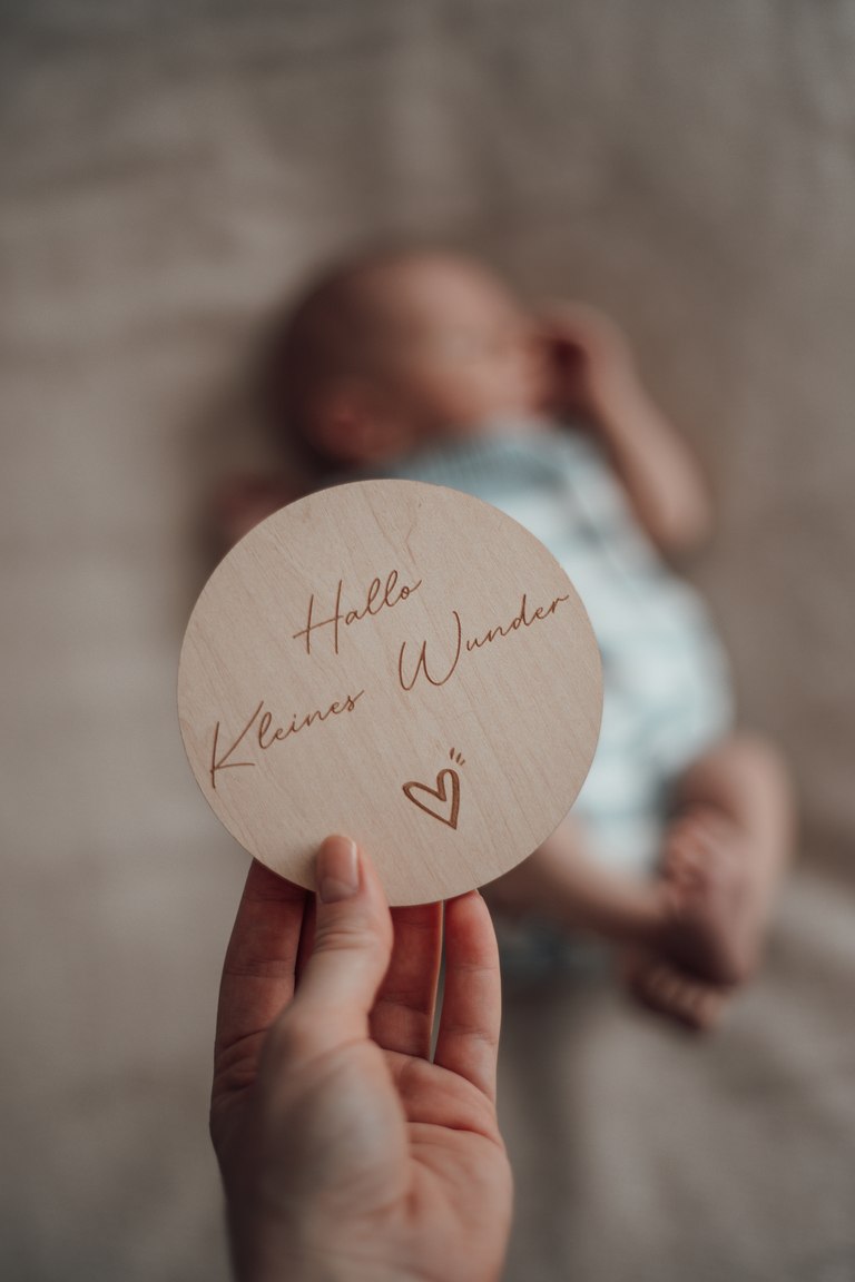 Ein Willkommensschild vor einem ruhenden Baby