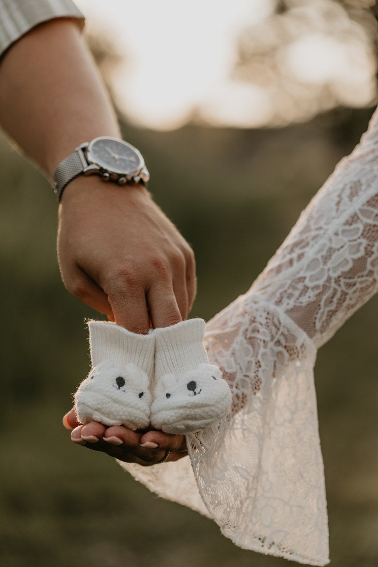 Werdende Eltern halten kleine Babyschuhe